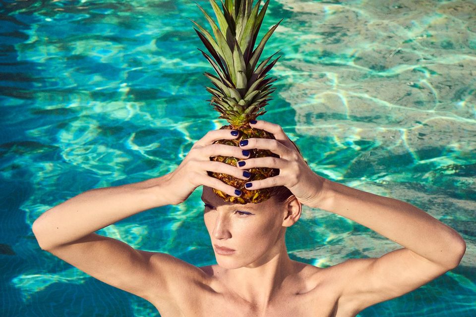 Früchte für die Schönheit: Frau im Pool mit Ananas