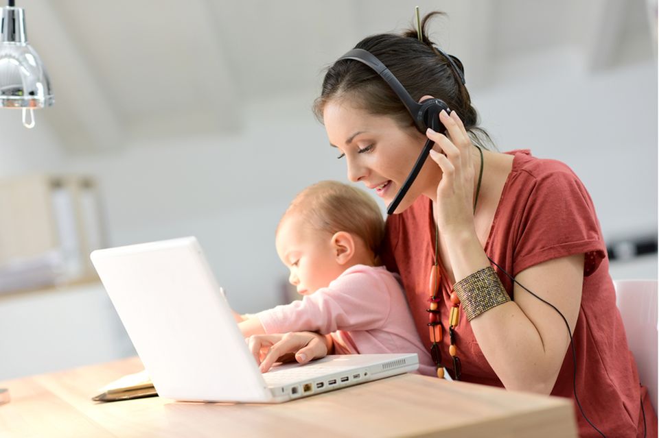 Elternzeit beantragen: Frau mit Kind beim Arbeiten