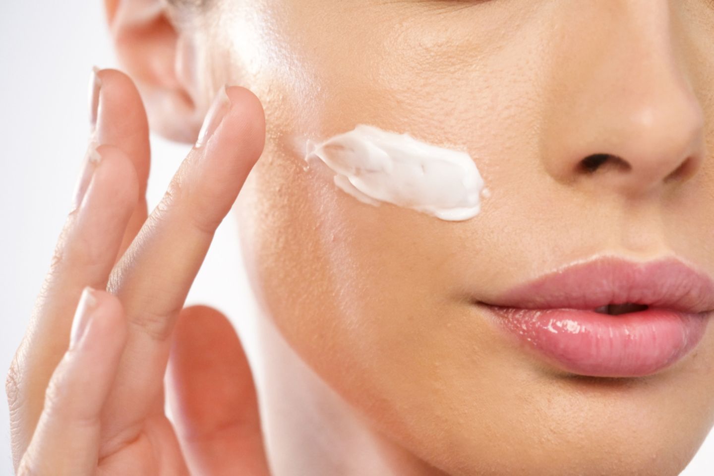 Hautpflege: Frau cremt sich das Gesicht ein