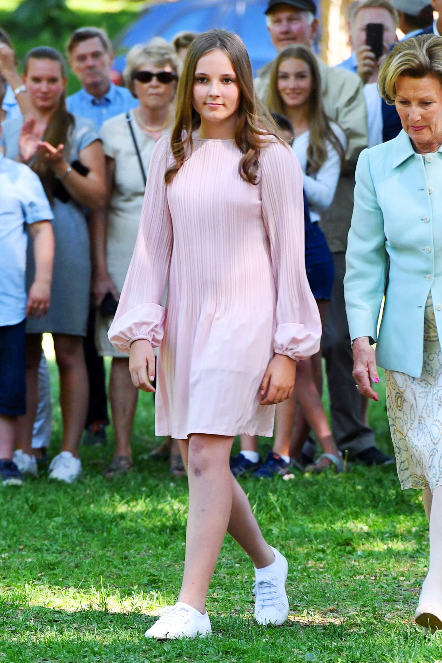 Die norwegische Prinzessin Ingrid Alexandra zeigt uns, wie feminine Eleganz geht: zu einem rosanen Chiffon-Kleid mit langen Puffärmeln kombiniert sie weiße Stoffschuhe - für die Extraportion Lässigkeit.