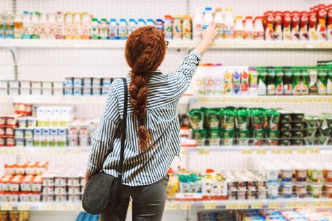 Frau steht vor dem Kühlregal im Supermarkt