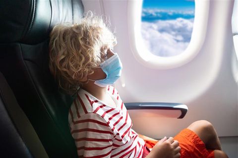Southwest Airlines: Kind sitzt mit Mundschutz am Fenster im Flugzeug