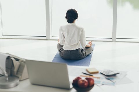 Entspannungsübungen im Büro: Frau meditiert im Büro