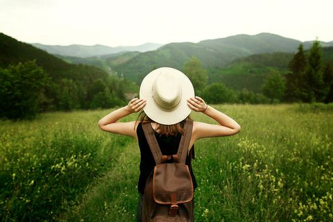 Nachhaltig reisen: Frau mit Hut in grüner Umgebung