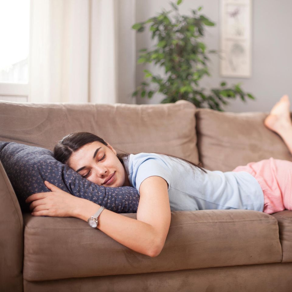 Schlafen bei Hitze: Frau schläft auf dem Sofa