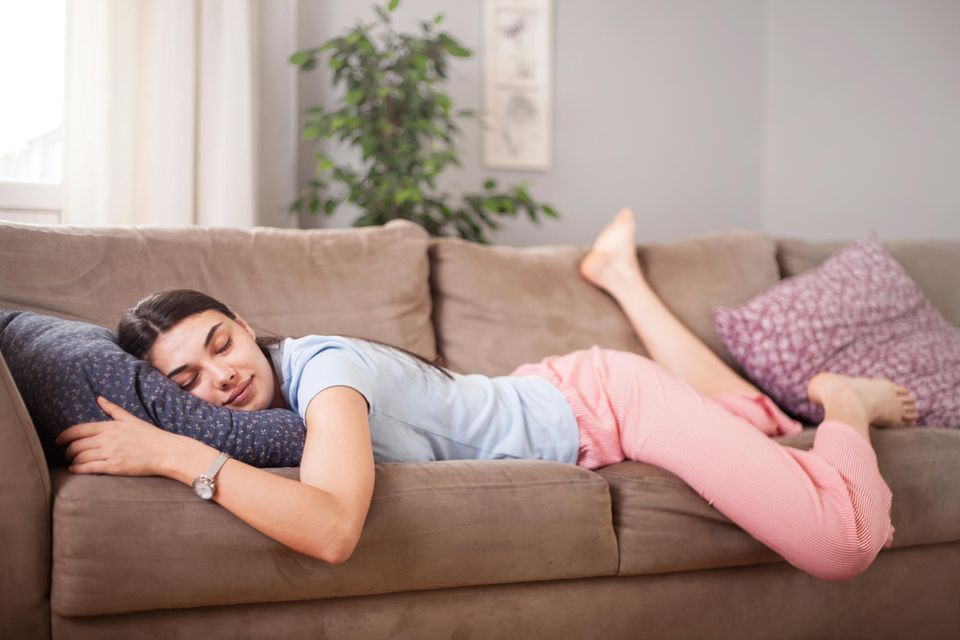 Schlafen bei Hitze: Frau schläft auf dem Sofa