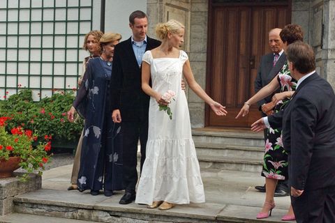 Schon am 23. August 2001, also zwei Tage vor ihrer Hochzeit mit Prinz Haakon, zeigte sich Mette-Marit in einem Kleid, das durchaus als legeres Brautkleid durchgehen könnte. Das weiße Dress mit Abnähern am Saum kombinierte sie zu goldenen Ballerinas. In Sachen Haarstyling setzte Mette-Marit auf einen tiefen Seitenscheitel und viele in die Haare eingeflochtene Bänder – so wie man es damals eben trug.