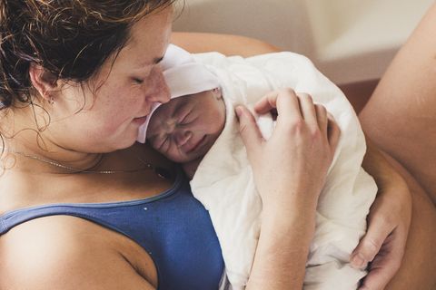 Ratschläge zur Geburt: Mutter hält ihr neugeborenes Baby im Arm