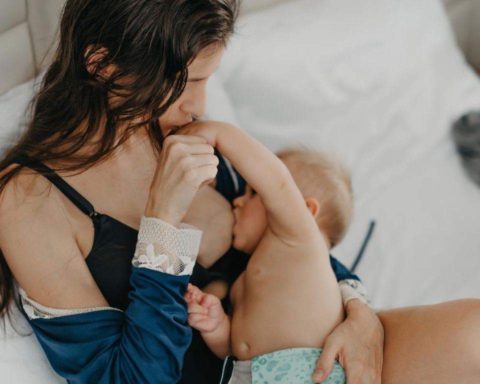 Postpartum Unfiltered: Frau mit Baby an Brust
