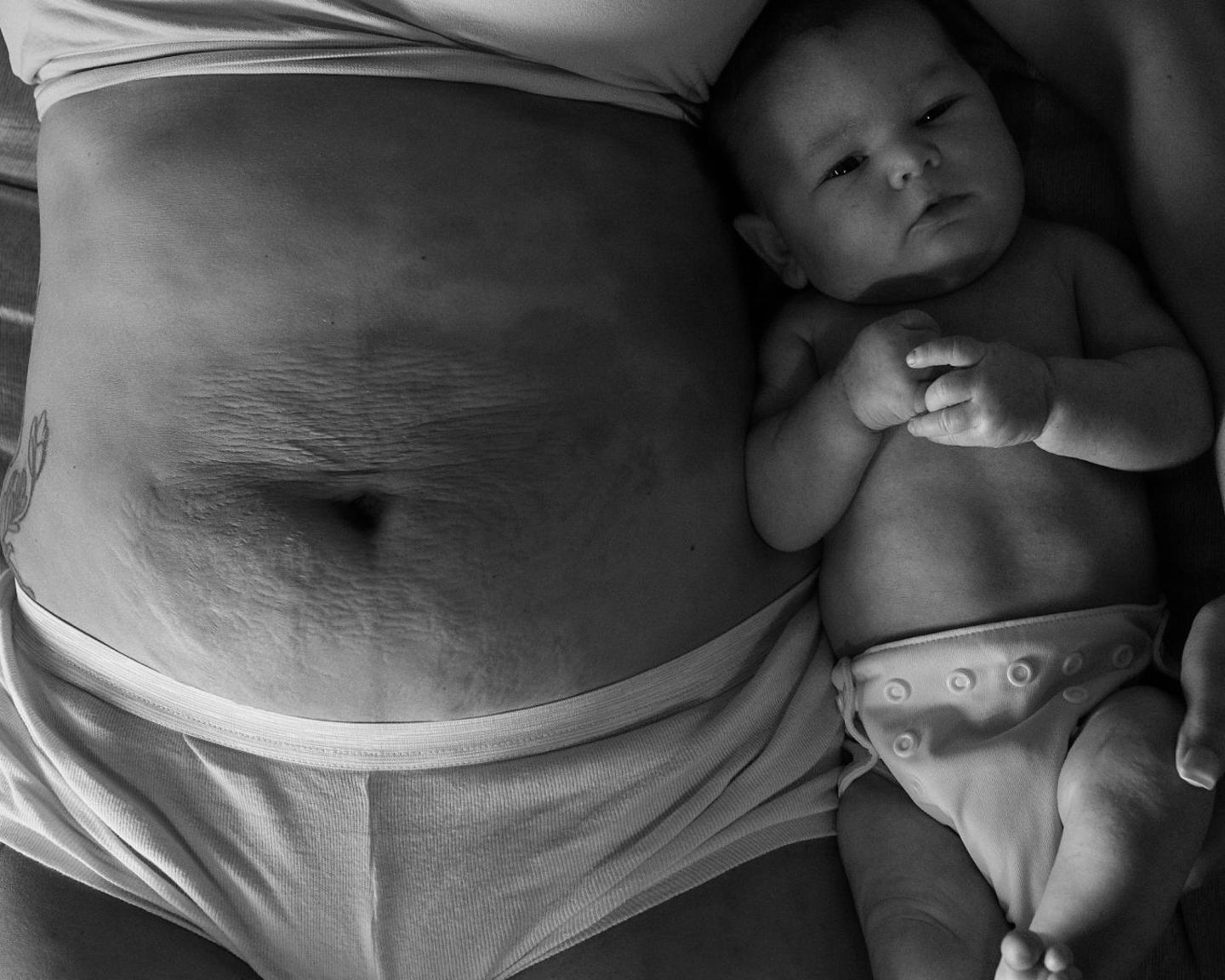 Postpartum Unfiltered: Baby liegt neben Mutter