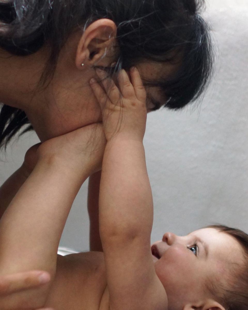 Postpartum Unfiltered: Baby fässt ins Gesicht der Mutter