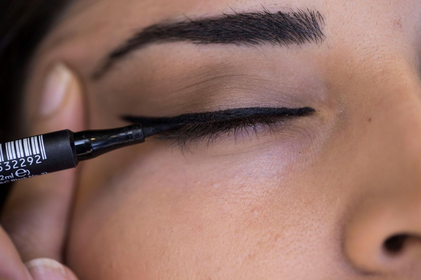 Eyeliner: Frau trägt schwarzen Eyeliner auf