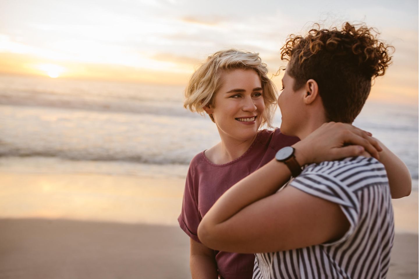 Lesbisches Paar geht am Strand spazieren