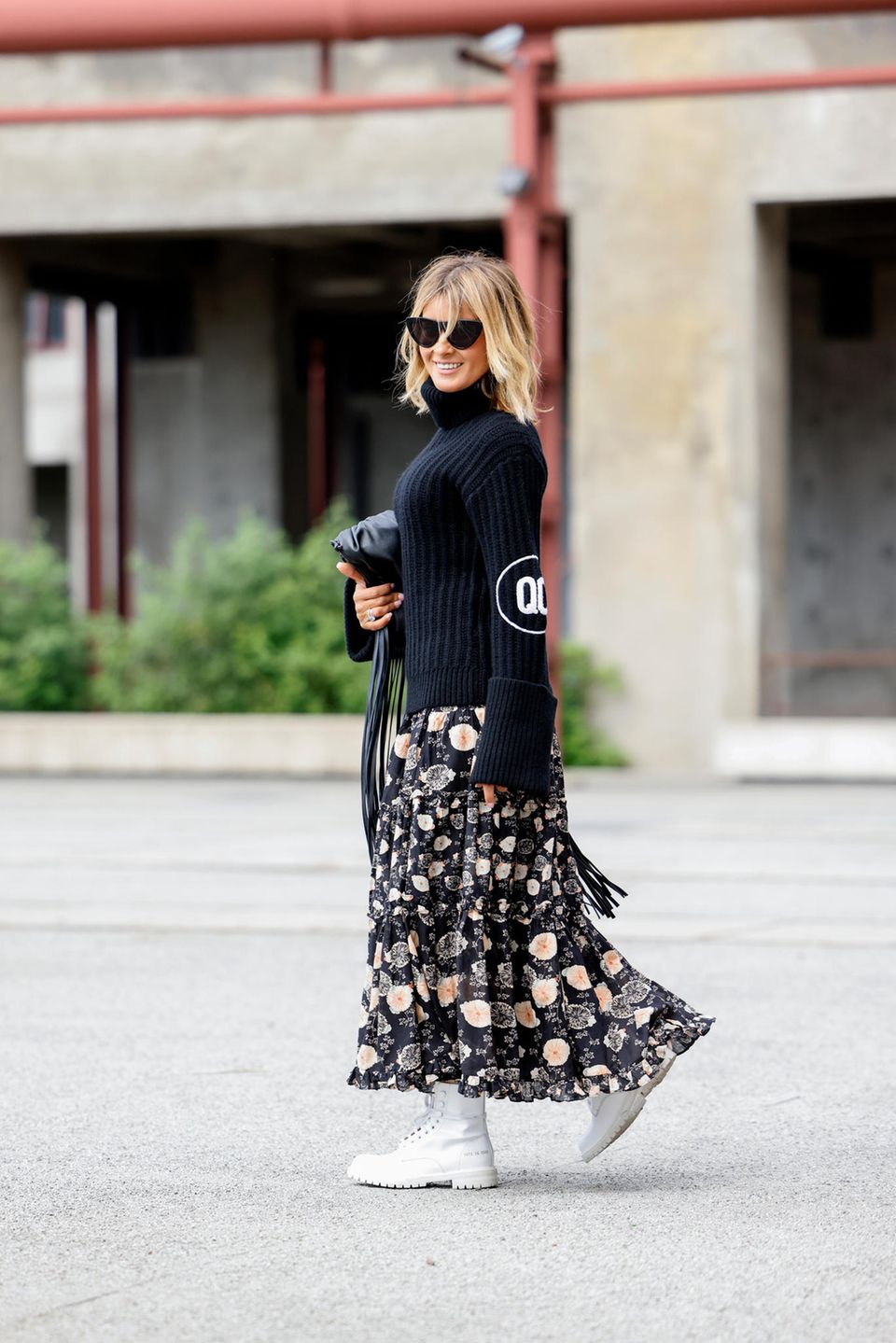 Blumenrock: Frau trägt einen schwarzen Pullover und einen Rock mit Blumenmuster