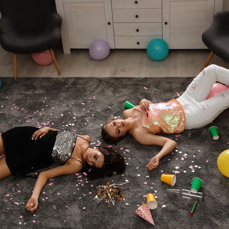 Party-Erfahrungen: Erschöpfte Gäste liegen im Party-Chaos auf dem Boden