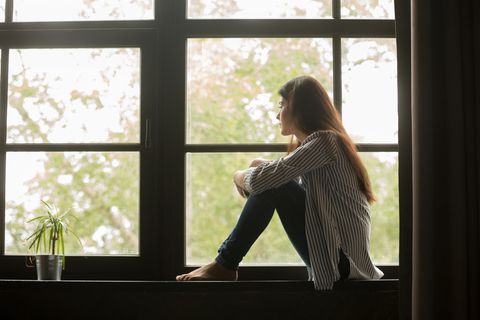 Gedankenkarussell stoppen: Frau schaut nachdenklich aus dem Fenster