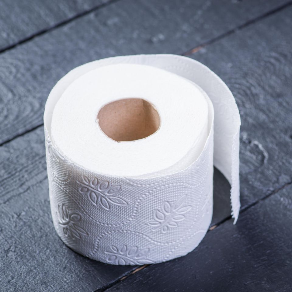 10 Fakten über Toilettenpapier: Eine Rolle Toilettenpapier auf einem schwarzen Tisch.