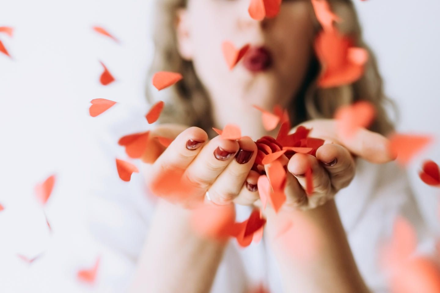 Liebe neu gedacht: Frau pustet Rosenblätter in die Kamera