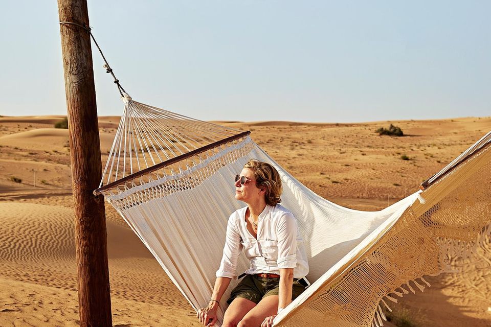 Dubai: Outdoor im Trend Dubai: Frau auf einer Hängematte in der Wüste
