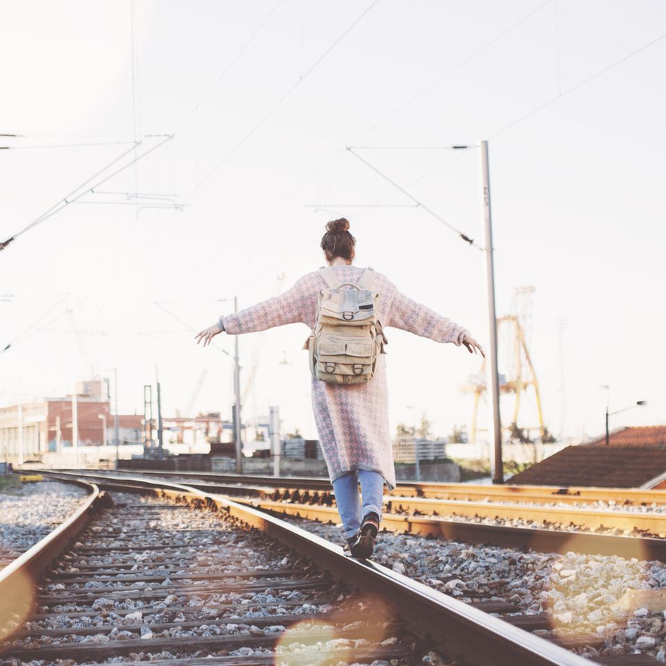 Psychologie: Eine Frau balanciert auf Eisenbahnschienen