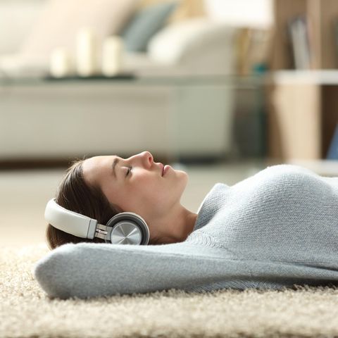 Me Time: Frau am Boden mit Kopfhörer