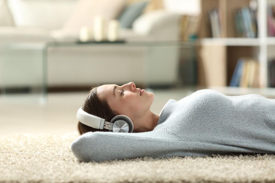 Me Time: Frau am Boden mit Kopfhörer