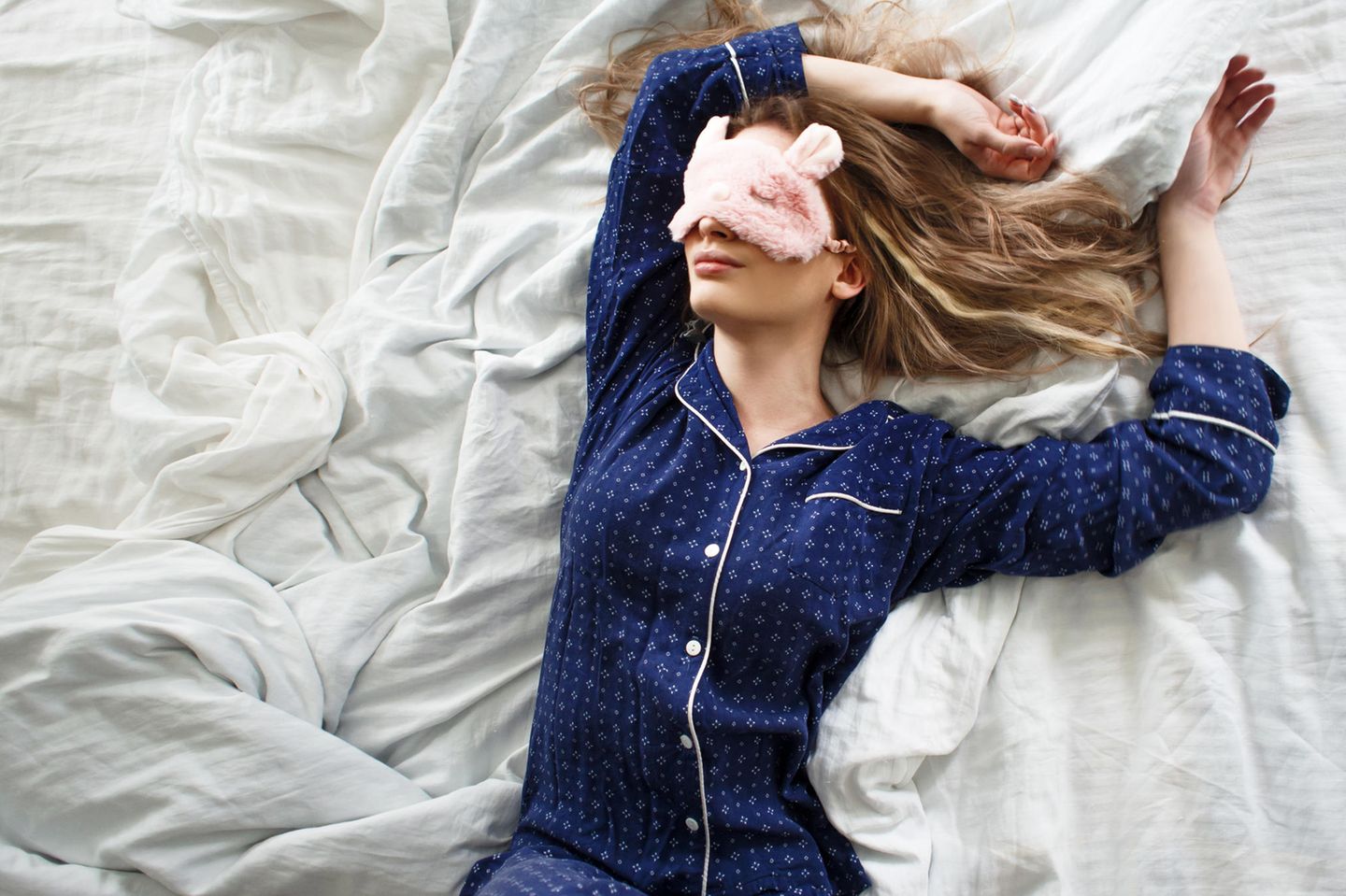 Ab in die Falle: Frau schläft im Pyjama und mit Schlafmaske
