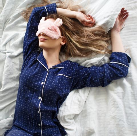 Ab in die Falle: Frau schläft im Pyjama und mit Schlafmaske