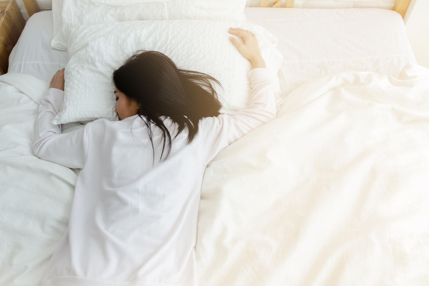 Frau schläft im Bett: Das bedeutet es, wenn du im Traum deinen Partner betrügst