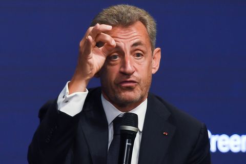Nicolas Sarkozy auf einer Bühne mit Mikrofon in der Hand