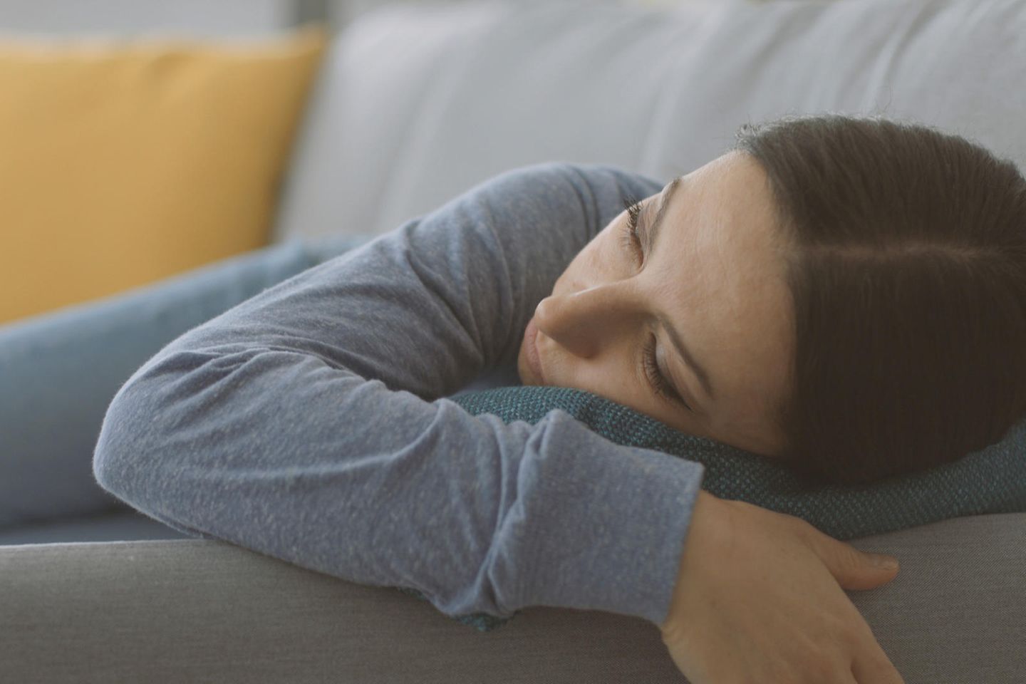 Stellvertreter-Burnout: Frau auf dem Sofa, starrt müde in die Luft