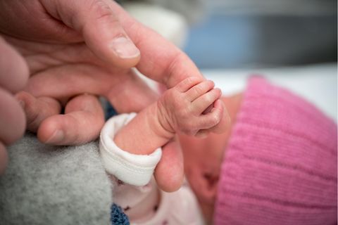 Eine erwachsene Hand hält eine Baby-Hand