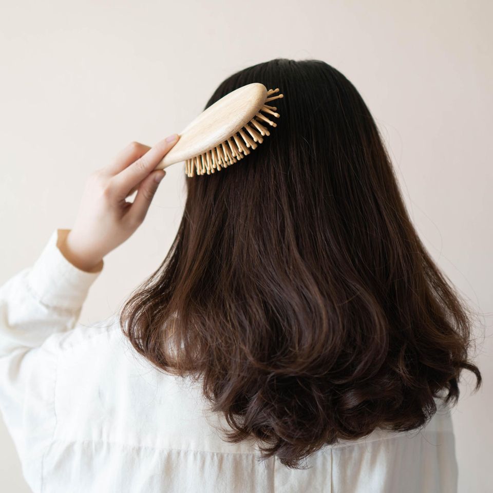 Die richtige Haarepflege: Frau bürstet ihre Haare