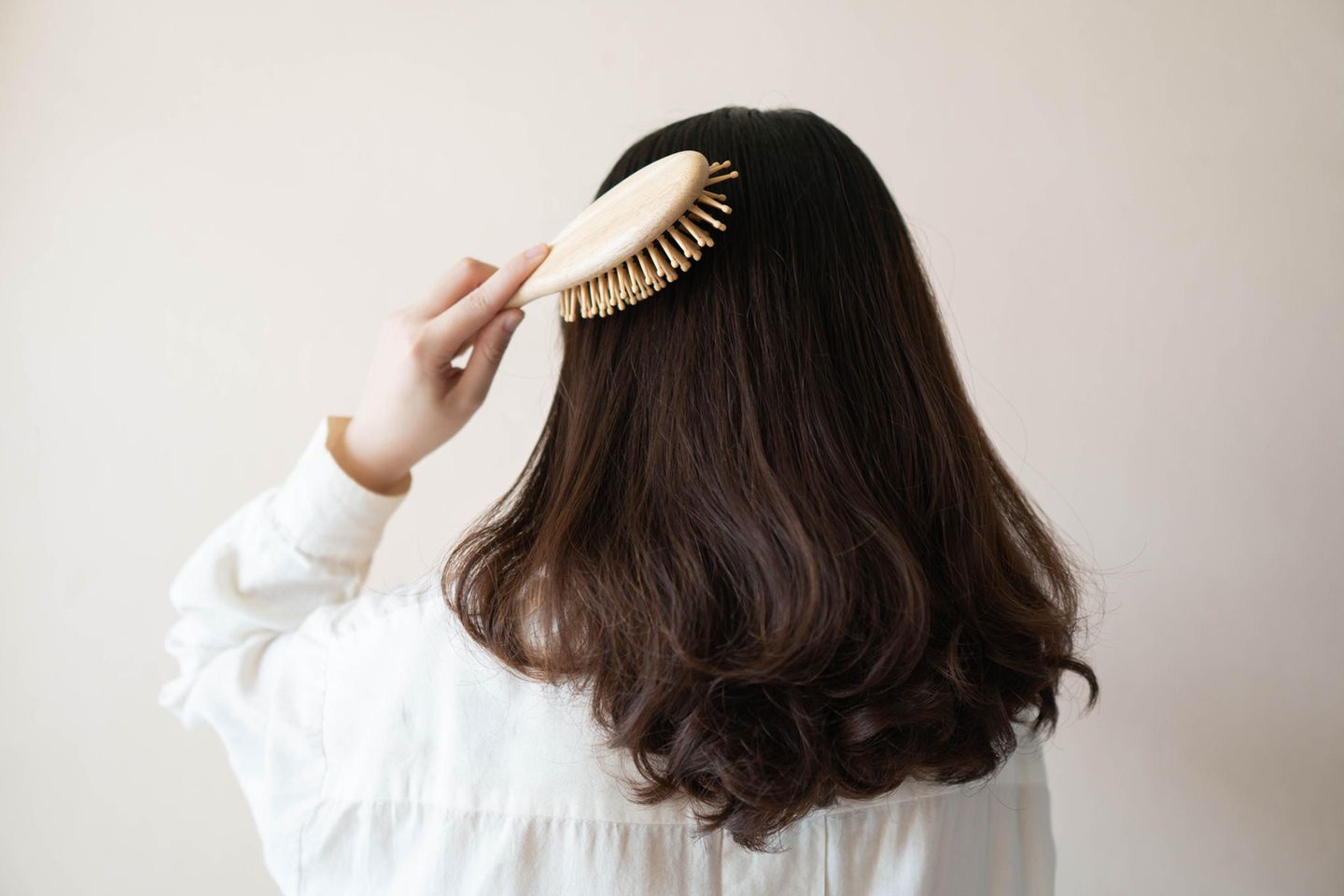 Die richtige Haarepflege: Frau bürstet ihre Haare