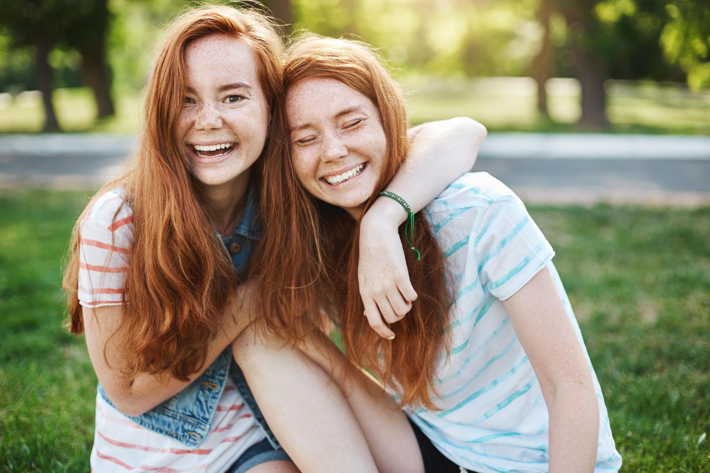 Zwillinge: Schwestern umarmen sich lachend