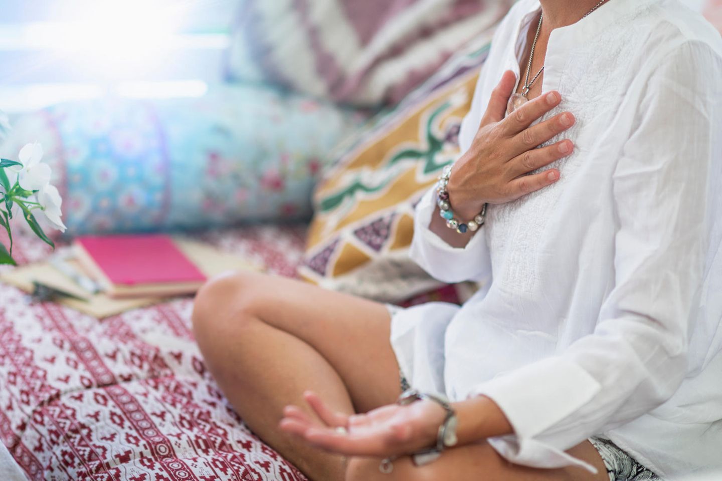 Metta-Meditation: Frau meditiert mit Hand auf dem Herzen