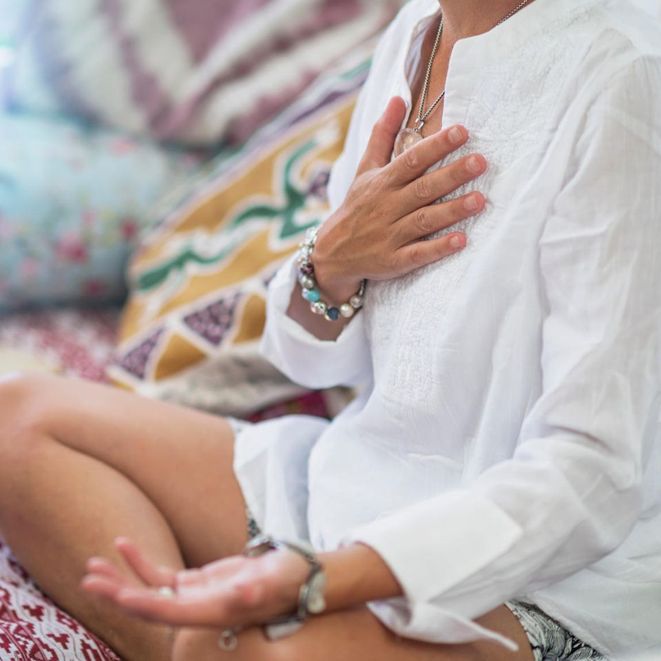 Metta-Meditation: Frau meditiert mit Hand auf dem Herzen