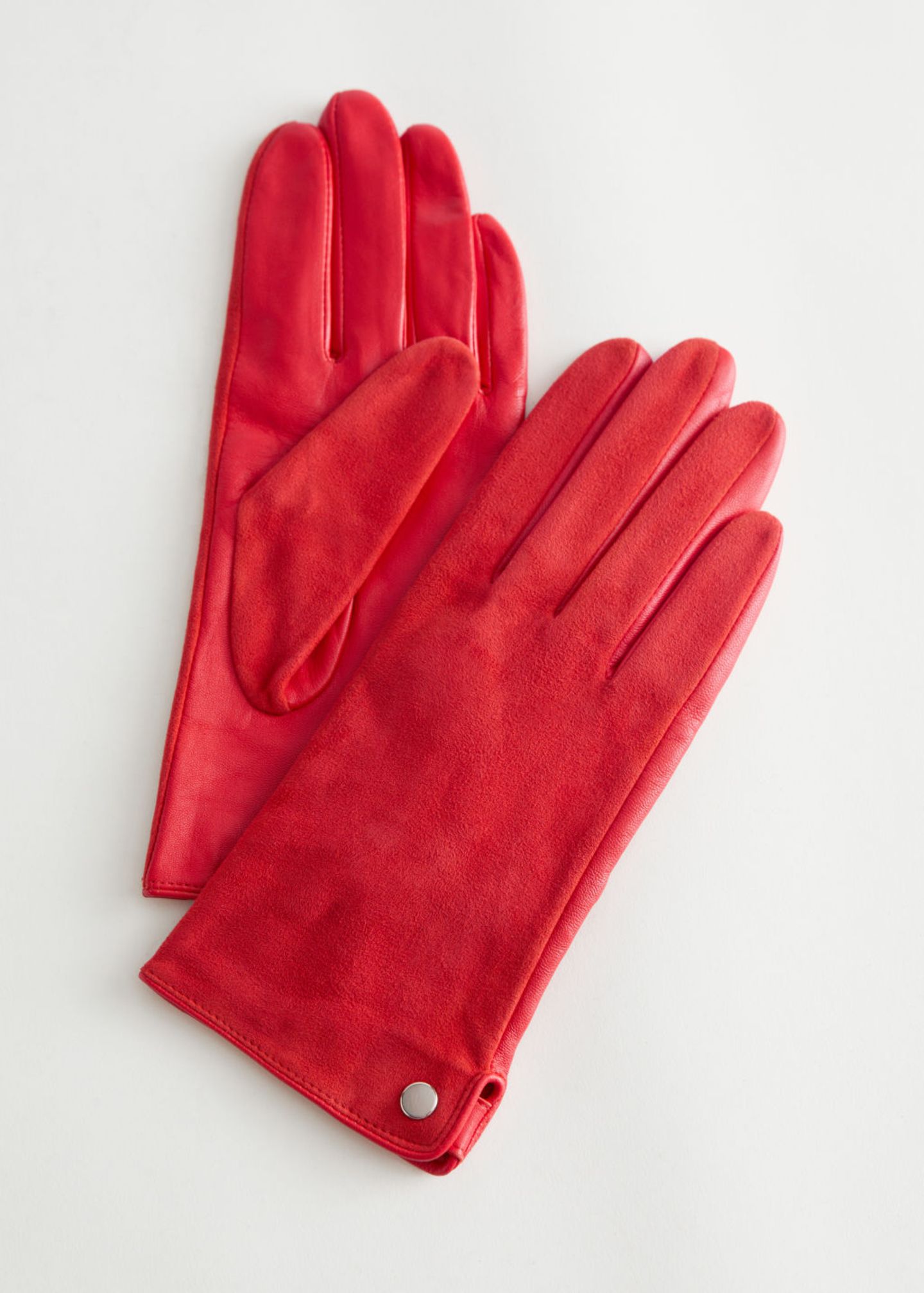 Anders als in den letzten Saisons tragen wir Lederhandschuhe in diesem Herbst nicht im klassischen Schwarz oder Braun, sondern im knalligen Rot. Um die auffällige Farbe wirken zu lassen, sollte beim restlichen Outfit auf Zurückhaltung gesetzt werden. Rote Wildlederhandschuhe von & Other Stories, für ca. 60 Euro.