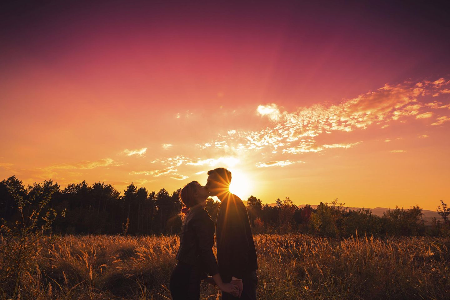 Beziehung: Ein Paar küsst sich im Sonnenuntergang