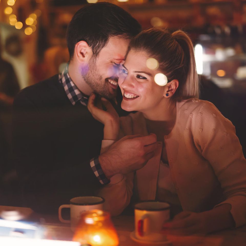 Ein verliebtes Paar kuschelt auf einem Date im Restaurant.