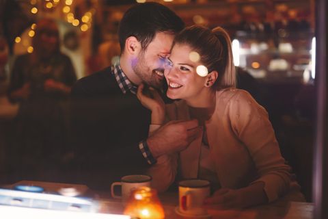 Ein verliebtes Paar kuschelt auf einem Date im Restaurant.