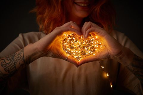 Horoskop: Frau mit Lichterkette in der Hand