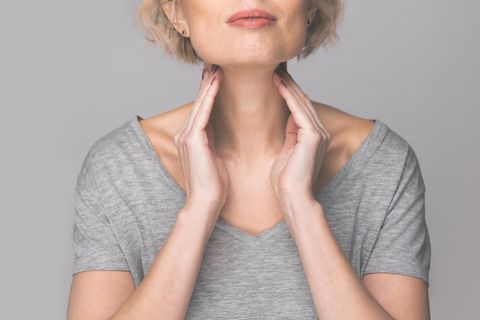 Schilddrüsenunterfunktion: Frau fasst sich an den Hals