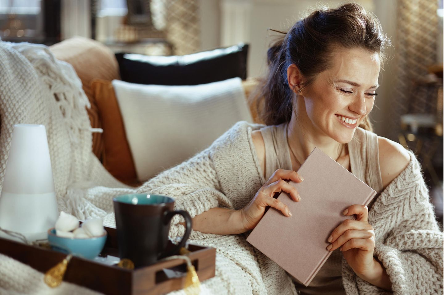 Lachende Frau mit Tagebuch in der Hand