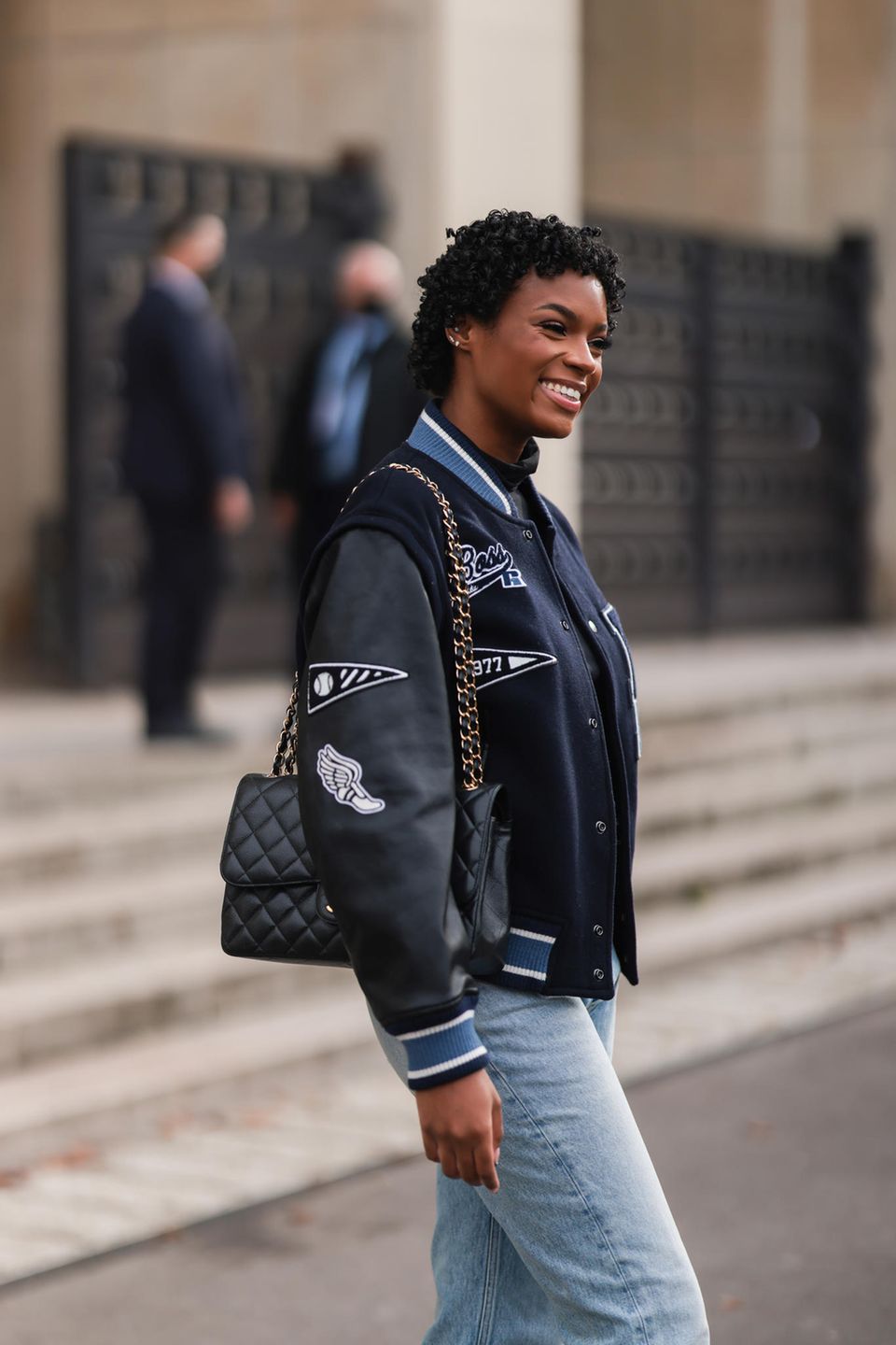 College Jacken aus den 90er Jahren feiern ihr Comeback: Frau in schwarzer College Jacke