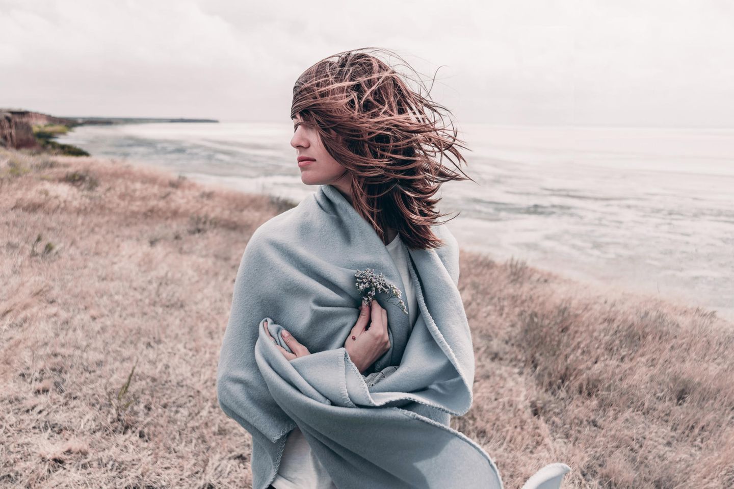 Horoskop: Eine Frau mit einer Decke am Meer