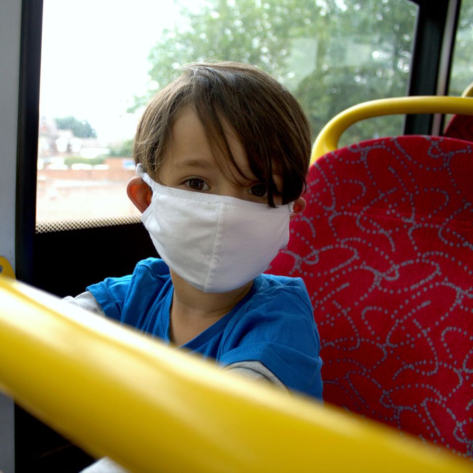 Corona aktuell: Junge mit Maske im Bus