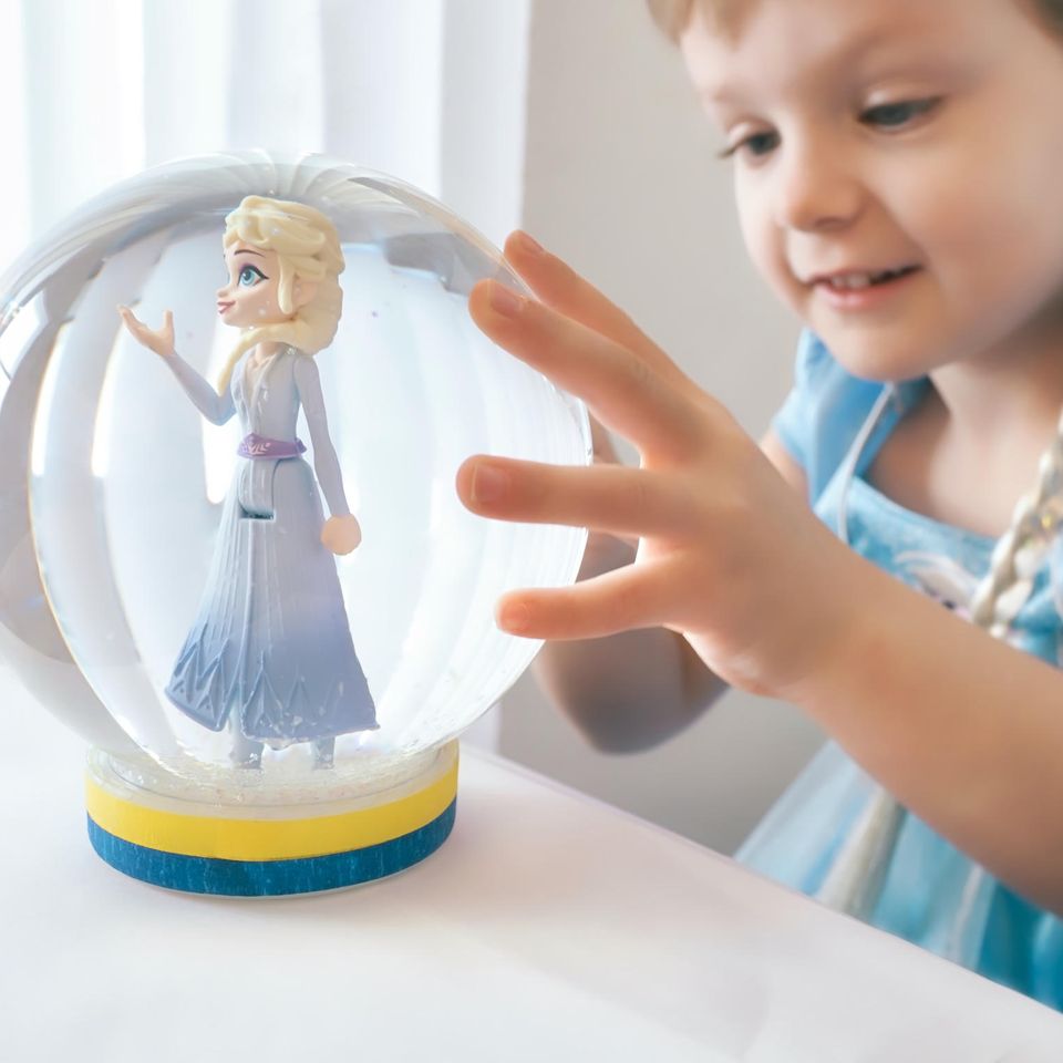 Kleines Mädchen mit Prinzessin Elsa Spielzeug