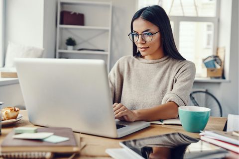 Prokrastination überwinden: Frau arbeitet konzentriert am Laptop