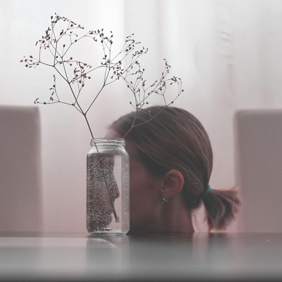 Psychologie: Frau spiegelt sich in einer Vase